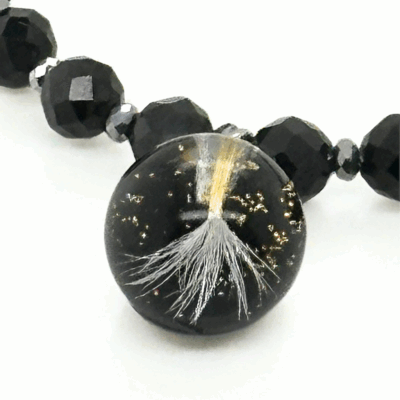 Bransoletka z czarnymi koralikami i brzoskwiniowym kryształkiem.