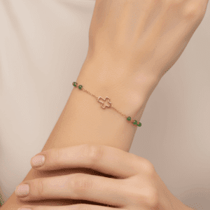 Złota bransoletka z krzyżykiem i zielonymi kamieniami