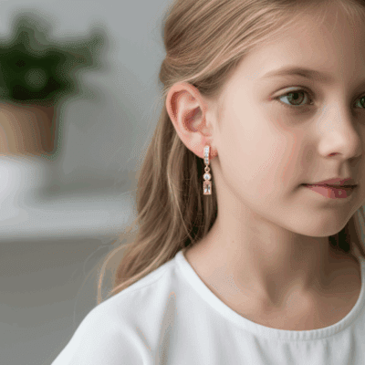 Długie, złote kolczyki w kształcie róży z wiszącymi elementami.