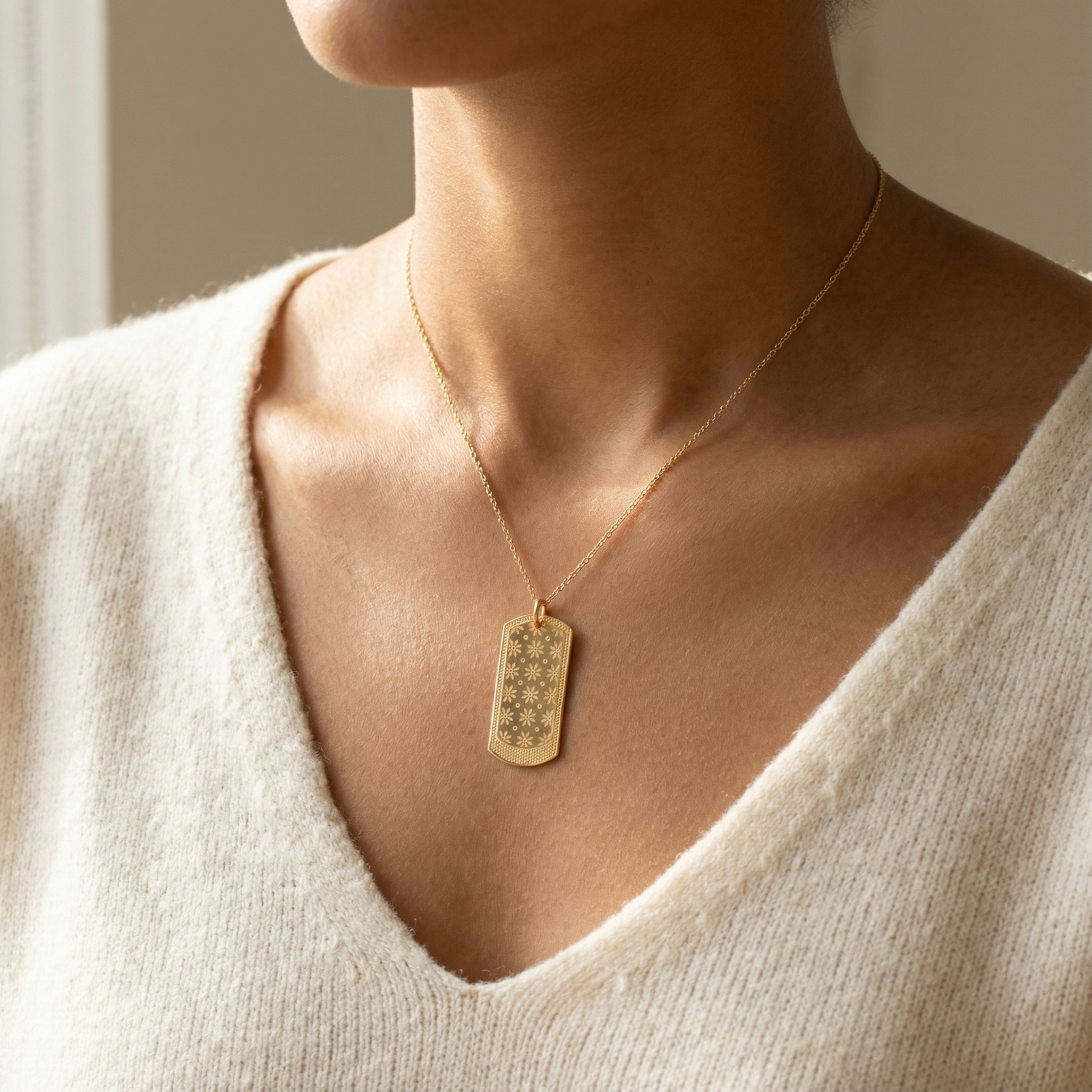 Złota zawieszka z kwiatowym grawerem na modelce