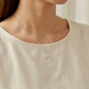 🩶 Srebro — biżuteria srebrna BigDIAMOND Kraków 32 Srebrny naszyjnik z ażurowym wzorem, na jasnej bluzce.