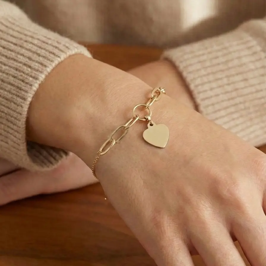 Złota bransoletka z sercem na ręce modelki