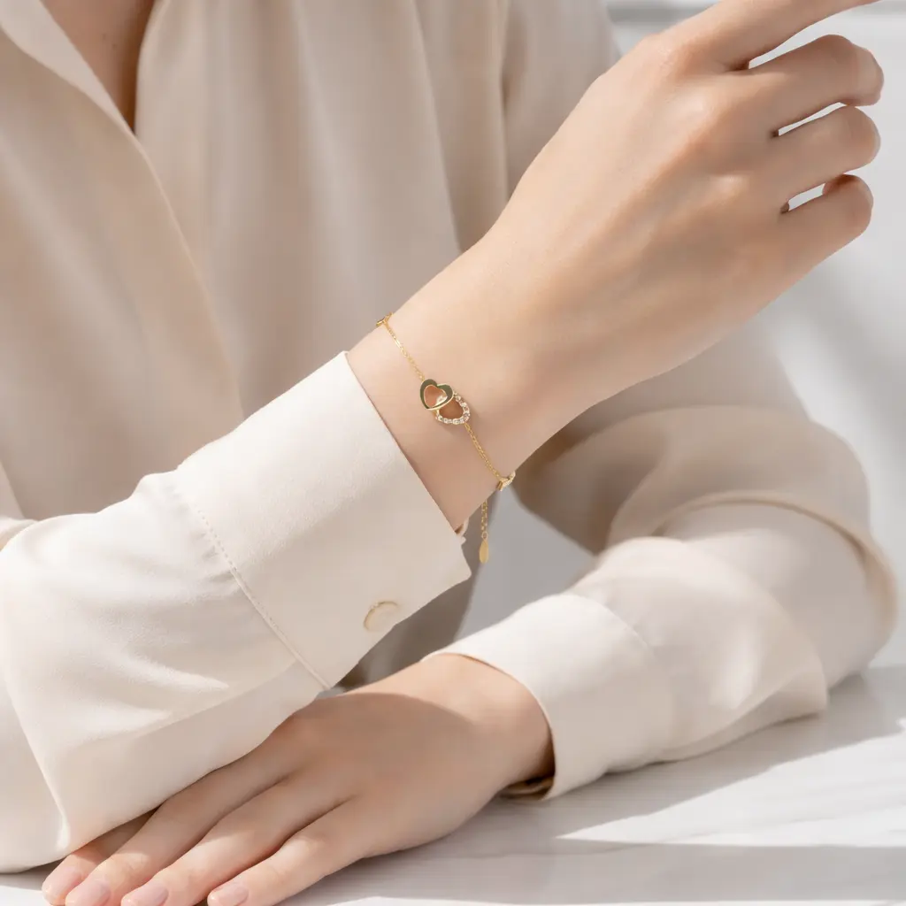 Złota bransoletka z sercem na ręce modelki