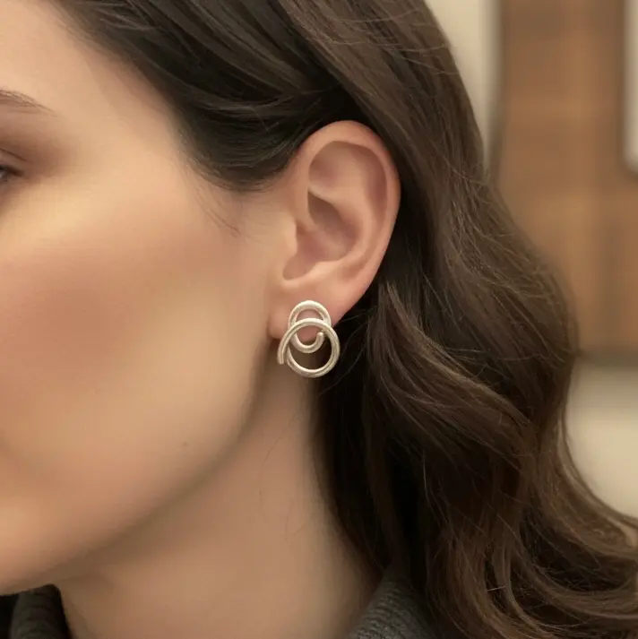 Srebrne spiralne kolczyki na modelce.