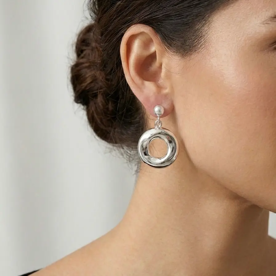 Srebrne kolczyki w kształcie kół, model na modelce