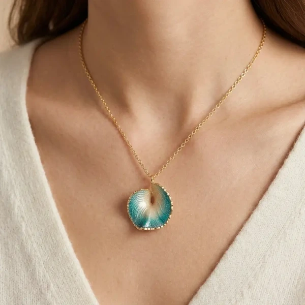 A close-up of a beautiful pendant necklace featuring a blue and gold design, worn on a person's neck.