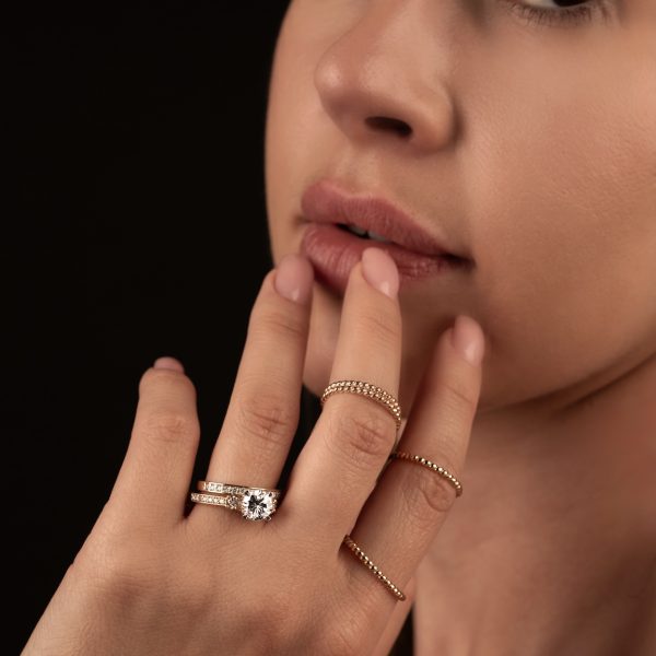 Złoty pierścionek BigDIAMOND z kamieniami sfotografowany w detalicznym zbliżeniu